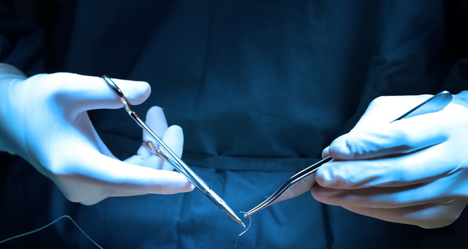 Doctor's hands with instruments preparing for surgery to treat severe AR